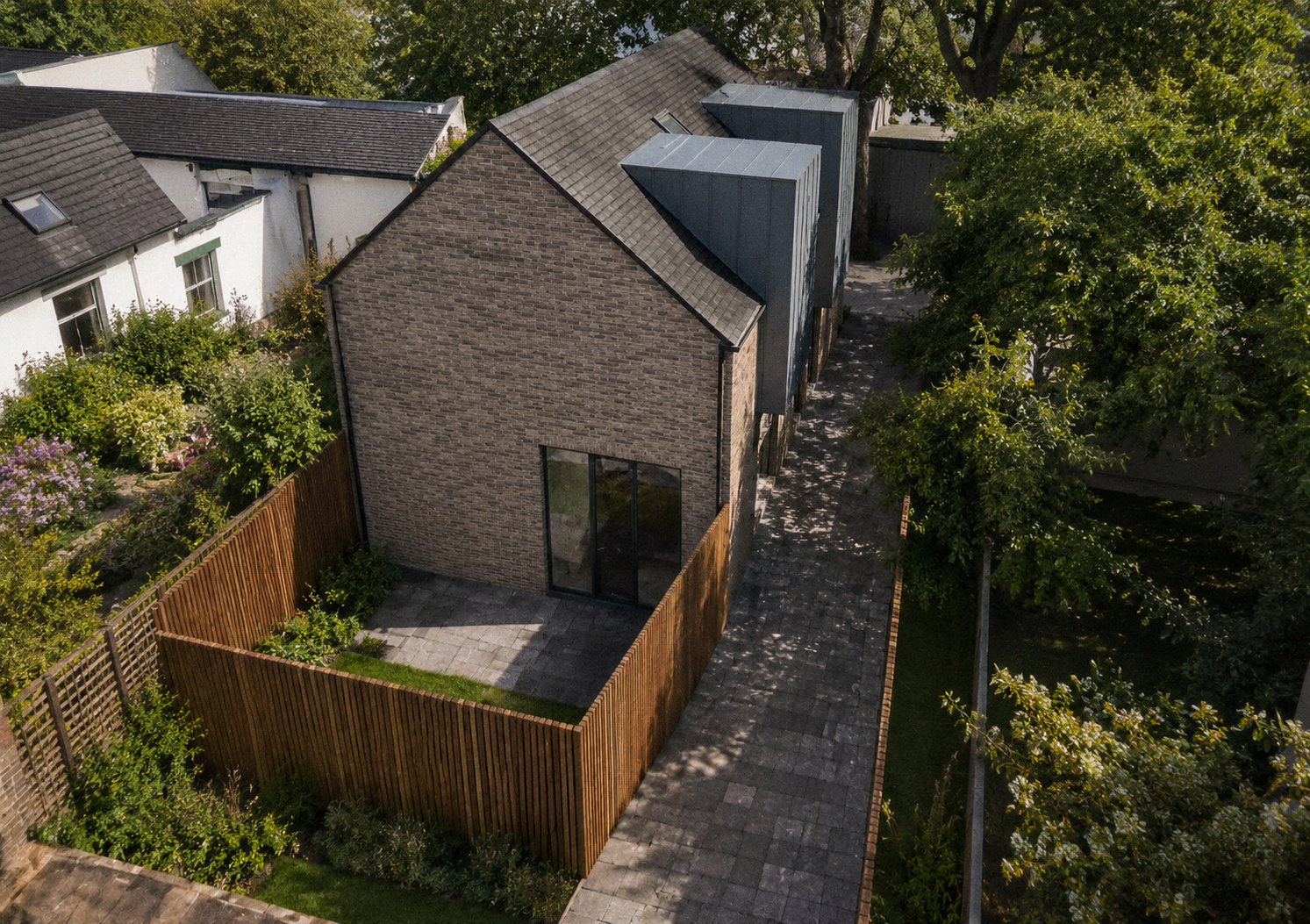 Contemporary Glasgow mews house with pale brick walls, stone boundary walls, timber gates and modern glazed extensions.