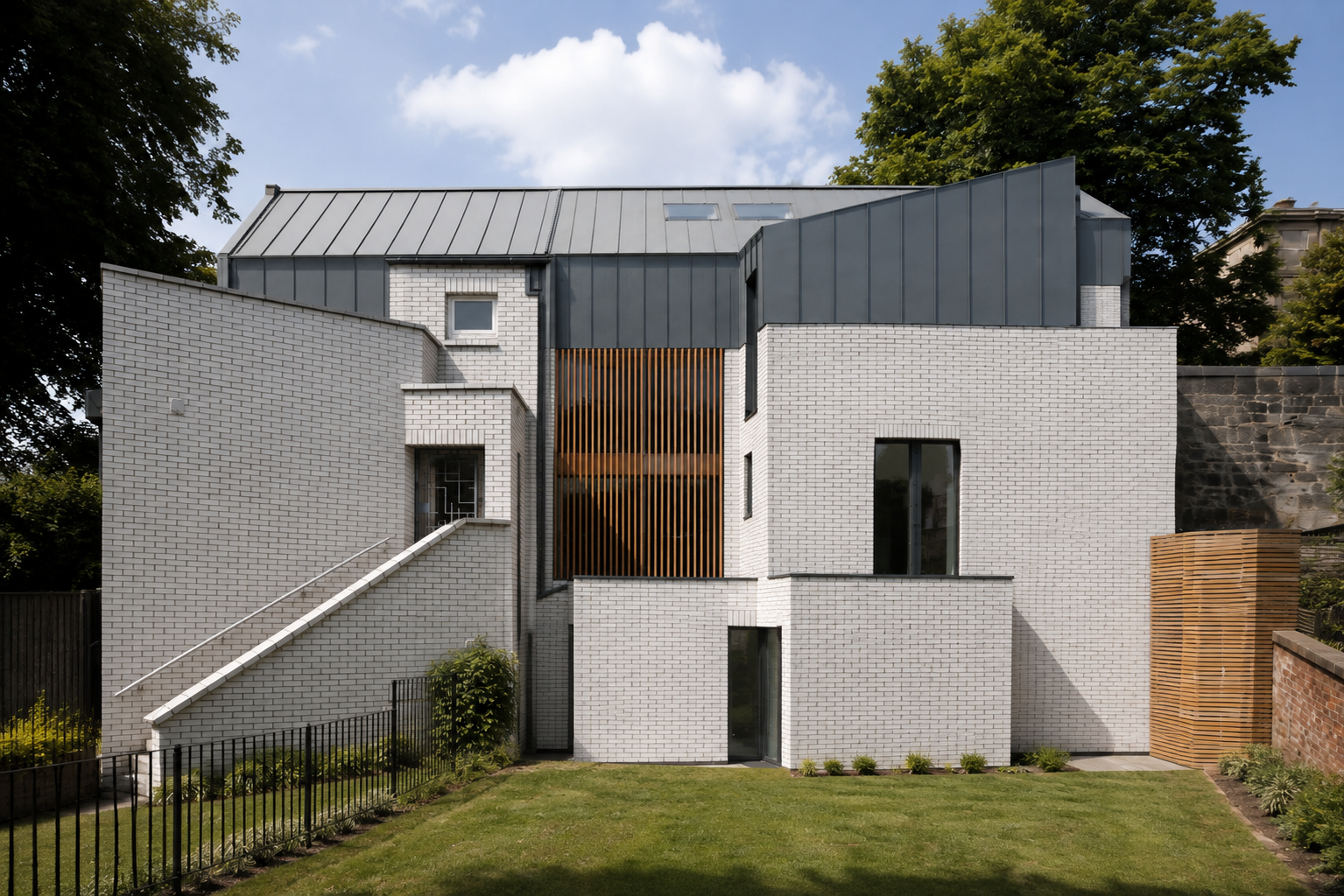 Contemporary Glasgow mews house overlooking a landscaped garden, with pale brick walls, dark metal roof cladding and timber screening.