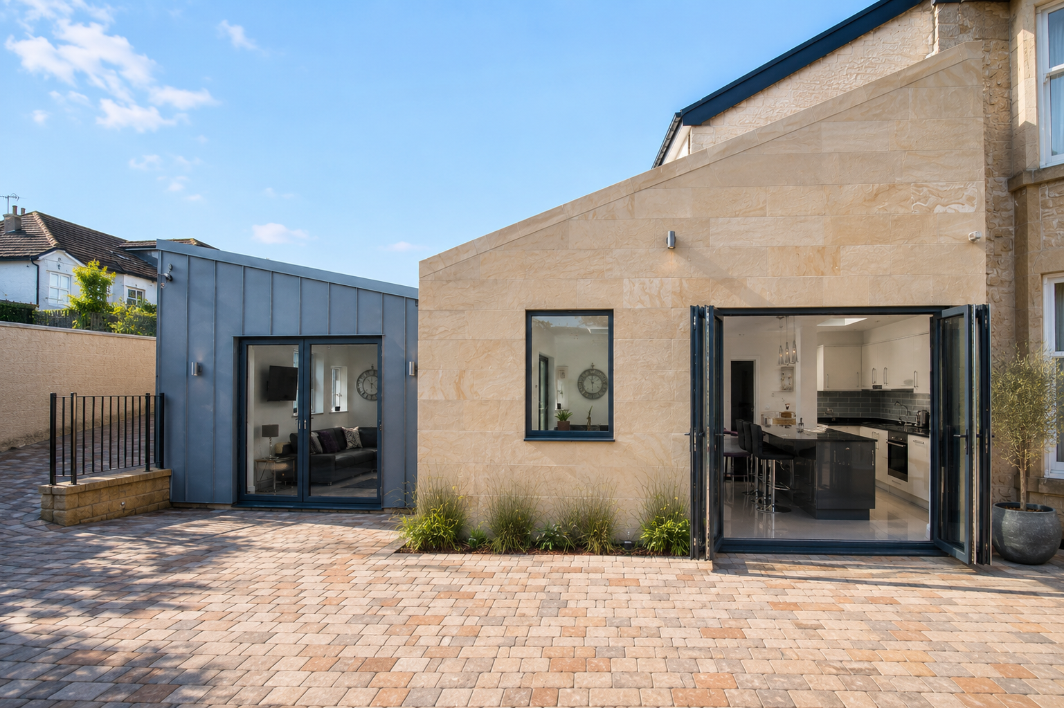 Rear elevation of a contemporary house extension in Cambuslang with stone walls, dark cladding and large glazed doors