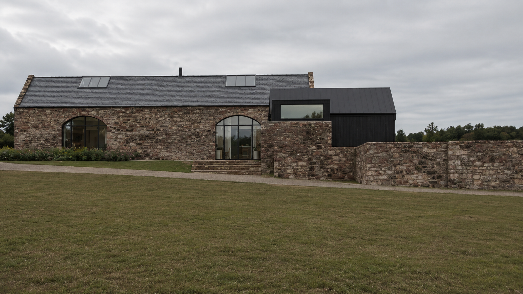 Modern barn conversion in Helensburgh with natural stone walls, black timber cladding and contemporary glazed openings.