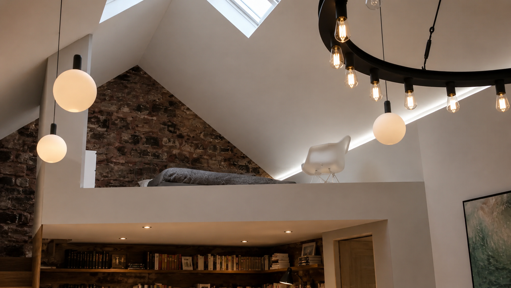 xt: Mezzanine level within a contemporary barn conversion, featuring exposed stonework, a vaulted ceiling and rooflight.