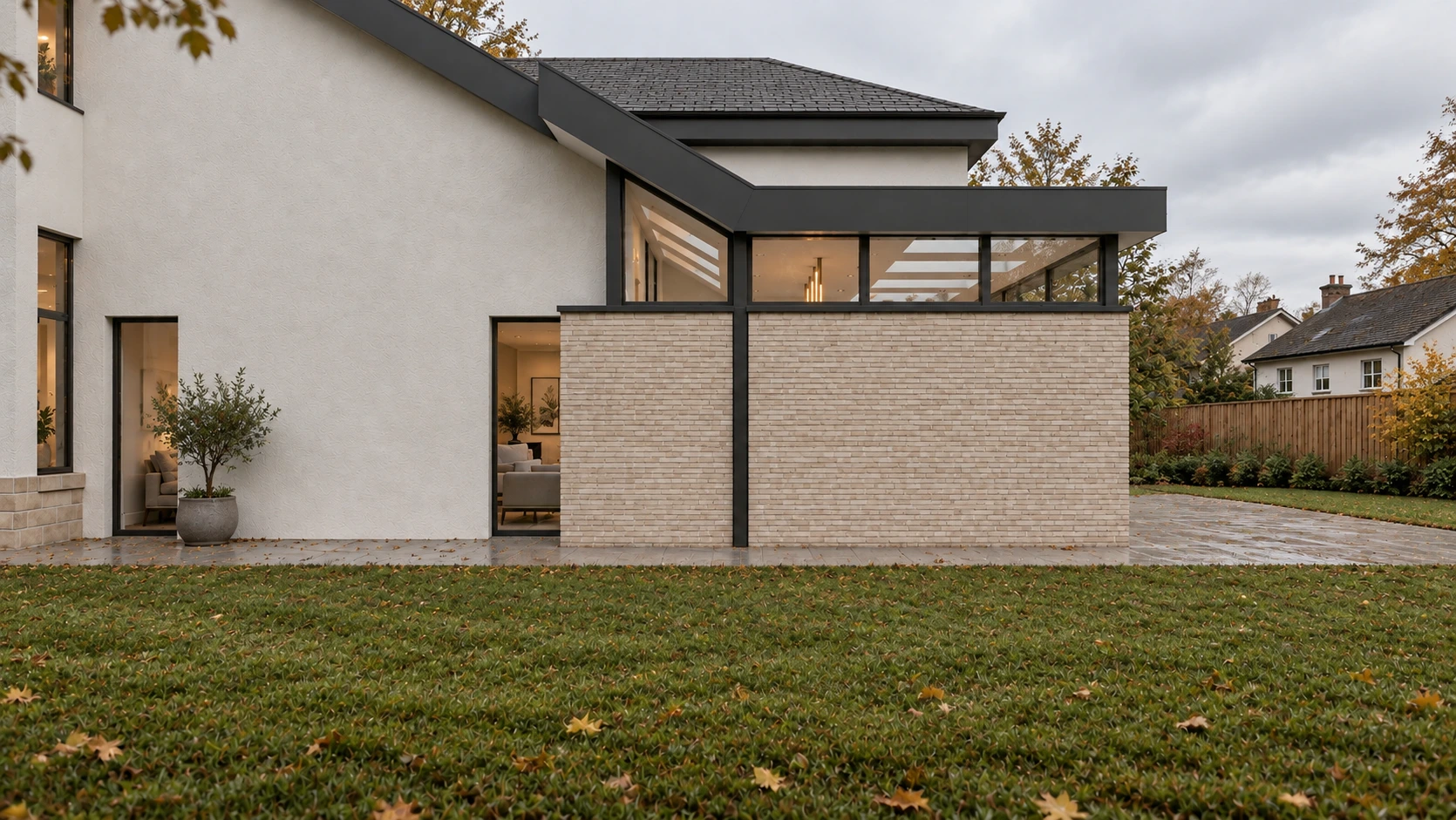 Modern rear extension with pale brickwork, rendered walls, dark-framed glazing and a landscaped lawn