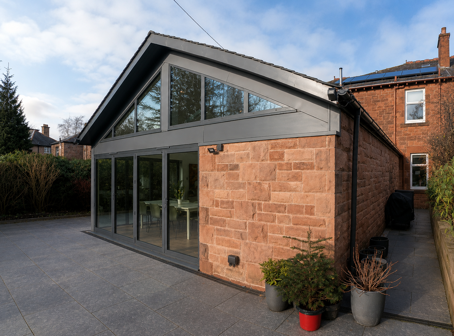 Contemporary extension to a Glasgow heritage property using matching sandstone and natural slate