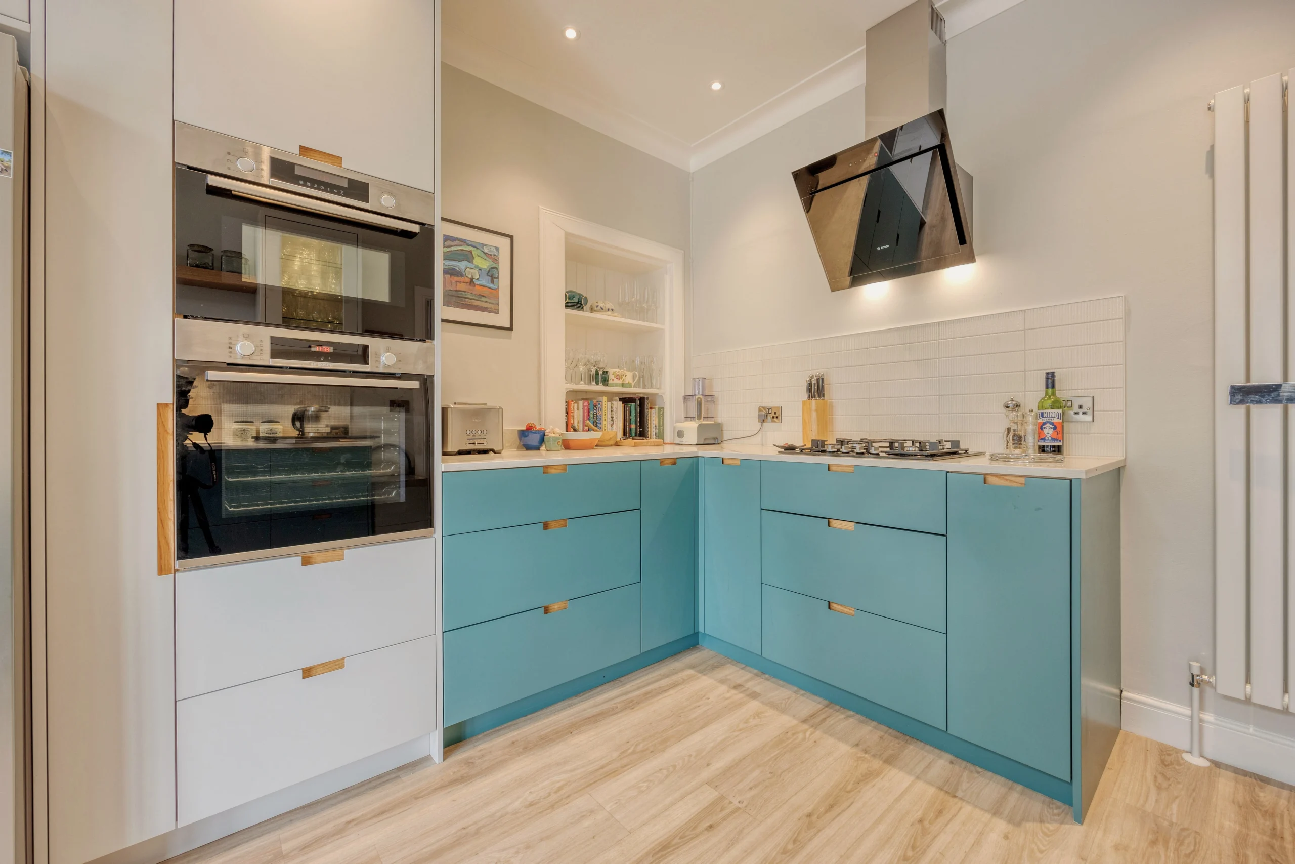 Contemporary blue and white kitchen with integrated appliances and bespoke storage