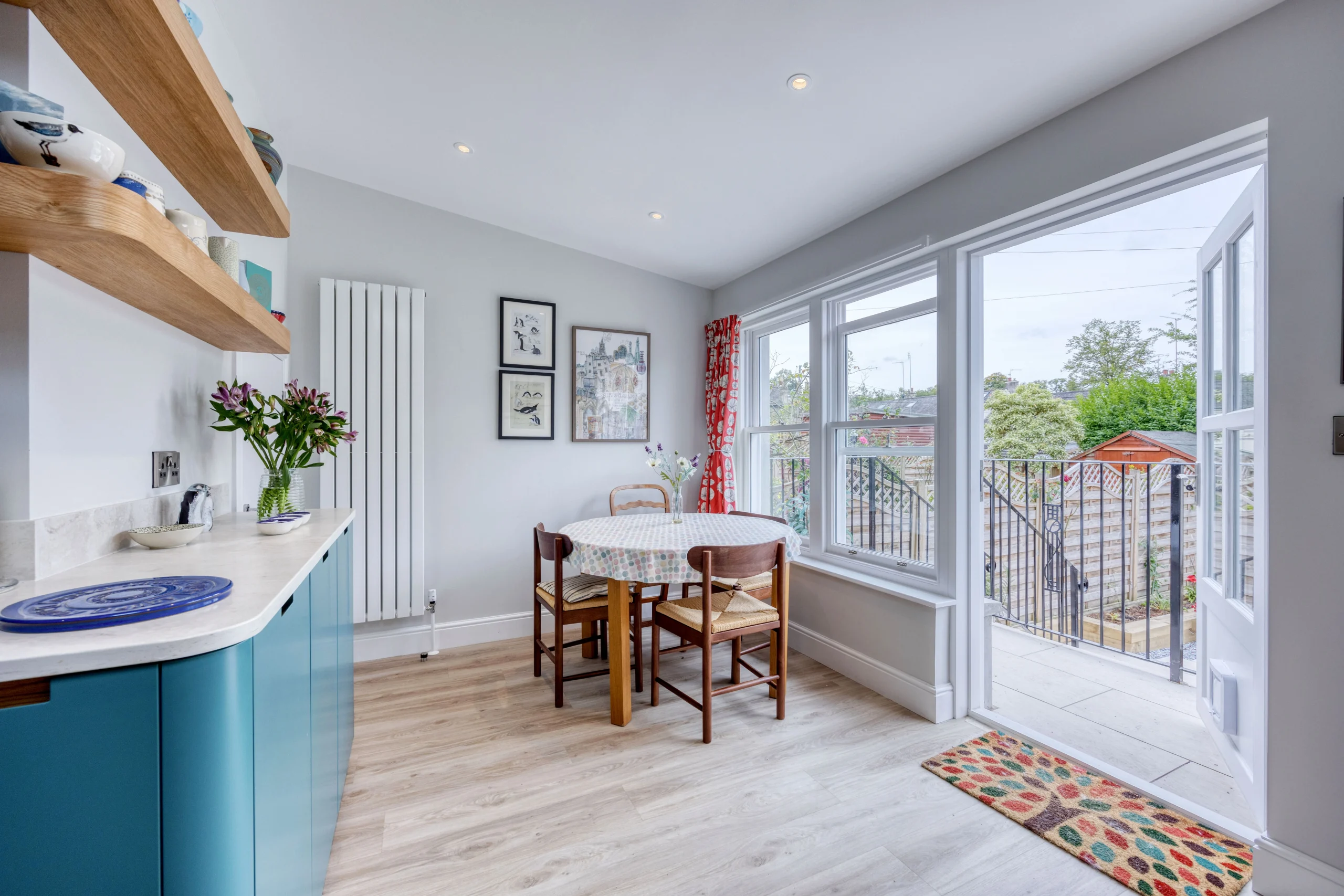 Bespoke blue kitchen cabinetry with integrated pull-out storage and oak detailing