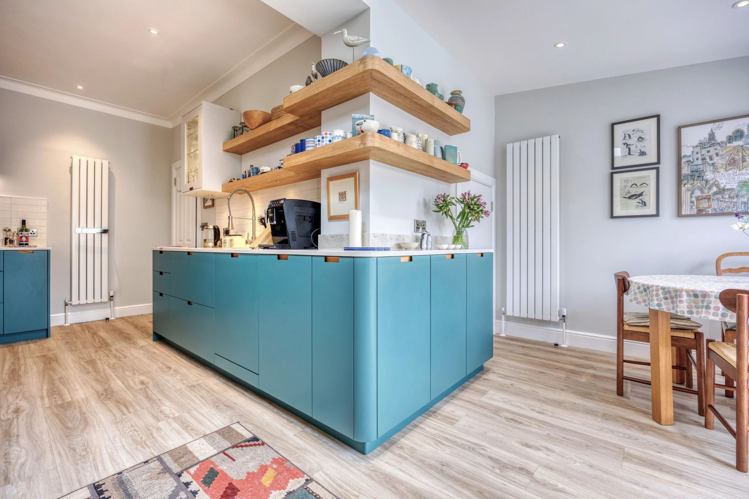 Bespoke oak shelving and glass-fronted storage above the worktop in a contemporary kitchen